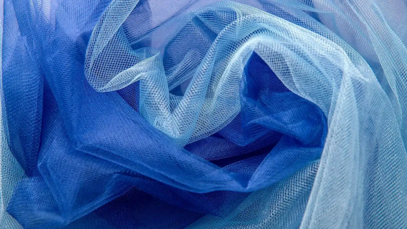 A close-up of luxurious blue Power Mesh fabric, showcasing its fine, stretchy texture ideal for activewear, lingerie and dancewear designs